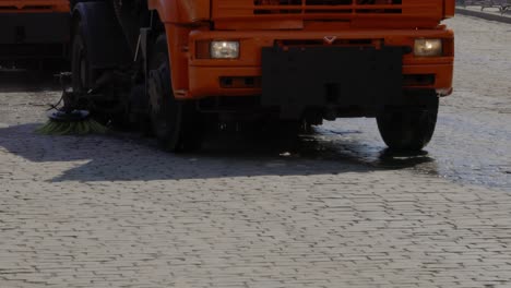 water tank truck with sweeper cleaning the streets