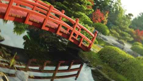 slider shot of red bridge in japanese garden