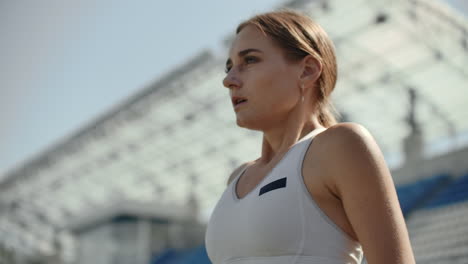 slow motion: athlete woman waiting in the starting block on running track