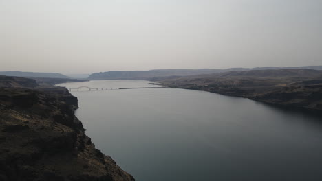 Drohnenaufnahmen,-Die-Einen-Ruhigen-Fluss-Und-Eine-Brücke-Zeigen