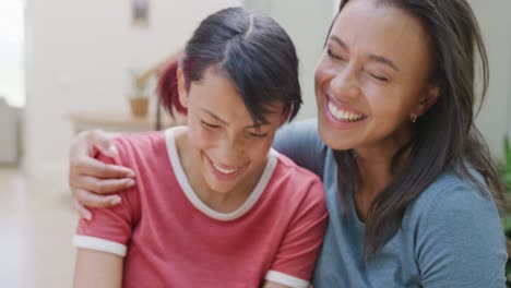 Portrait-of-happy-biracial-sisters-embracing-and-smiling-in-garden,-in-slow-motion