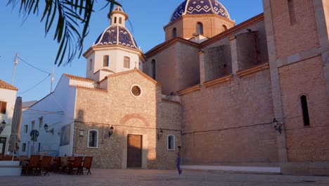 woman walks in altea's church square, spain, costa blanca