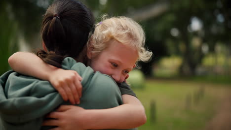 child, mother and hug at a park outdoor in nature