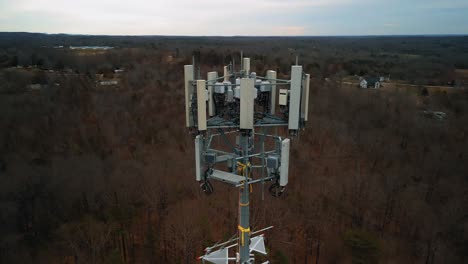 aerial shot rotating around cell phone tower in forest. close up