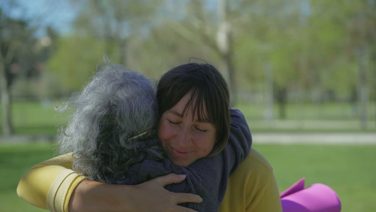 여자가 손을 흔들고, 다른 여자를 인사하고, 키스하고, 포옹합니다.