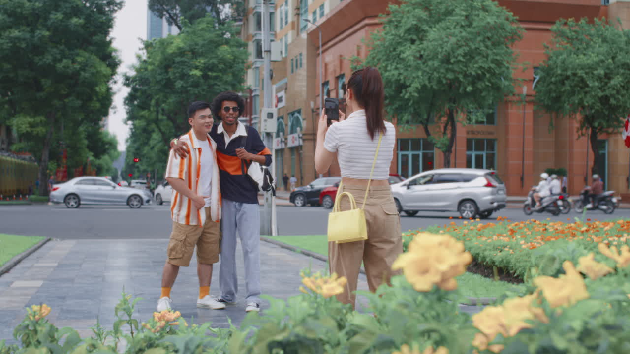 Femme photographiant ses amis avec un téléphone dans la rue