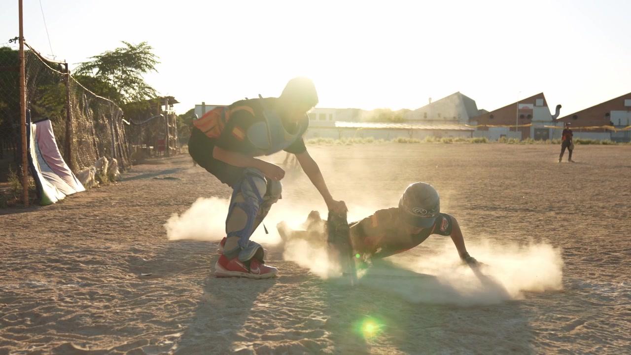 Jogador de Beisebol Deslizando para o Home Plate Durante Jogo ao Pôr do Sol