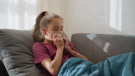 little child suffering from flu sneezing into white tissue while resting, natural light filtering through window, displaying discomfort and illness recovery