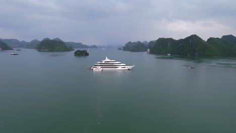 Antenne-Der-Schönen-Weißen-Luxusyacht,-Die-Bei-Sonnenuntergang-In-Ha-Long-Bay-Vietnam-Verankert-Ist