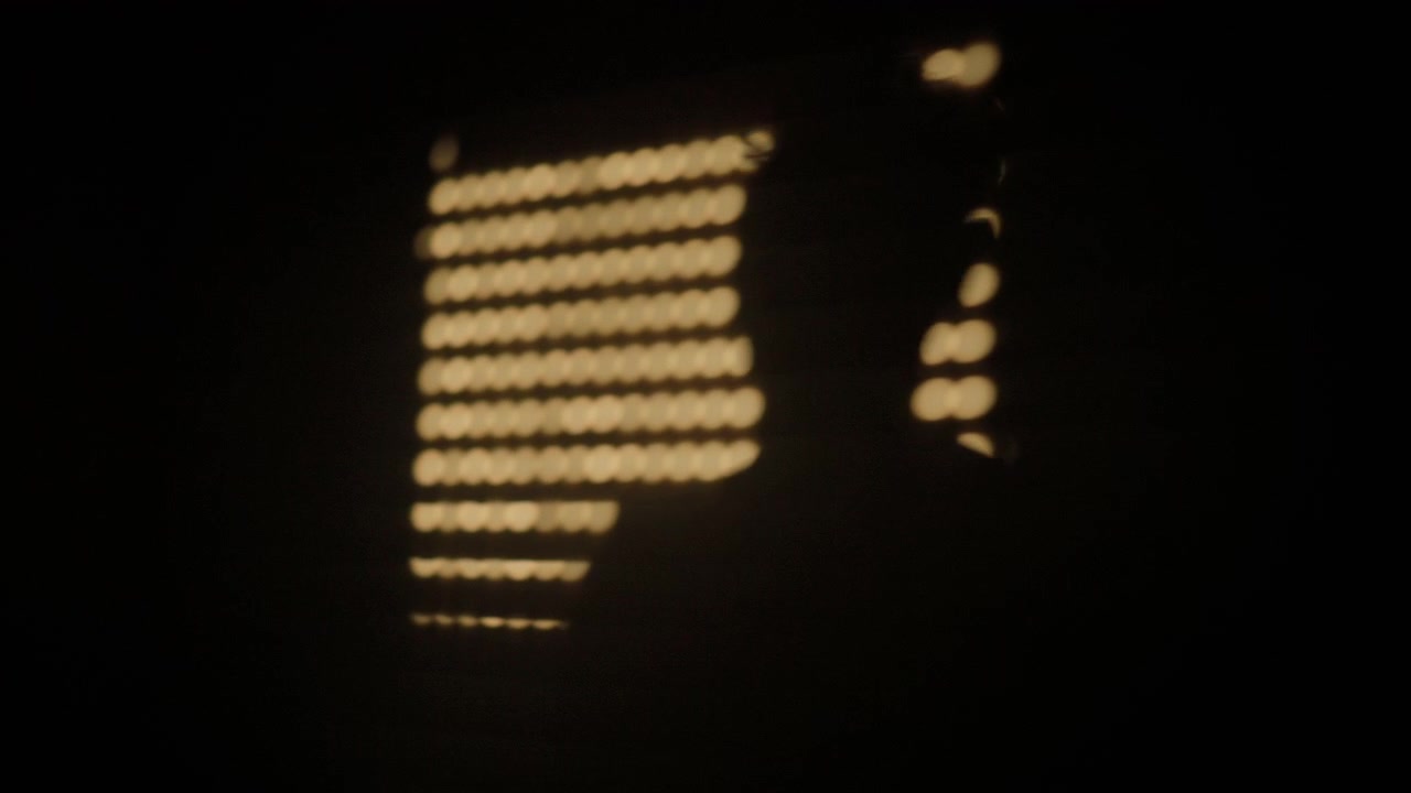 Human silhouette appearing in abstract bokeh lights creating a dark and warm light effect. Abstract pattern of bright circles
