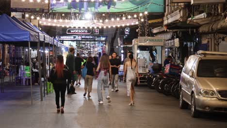 pedestrians walking through a lively night market