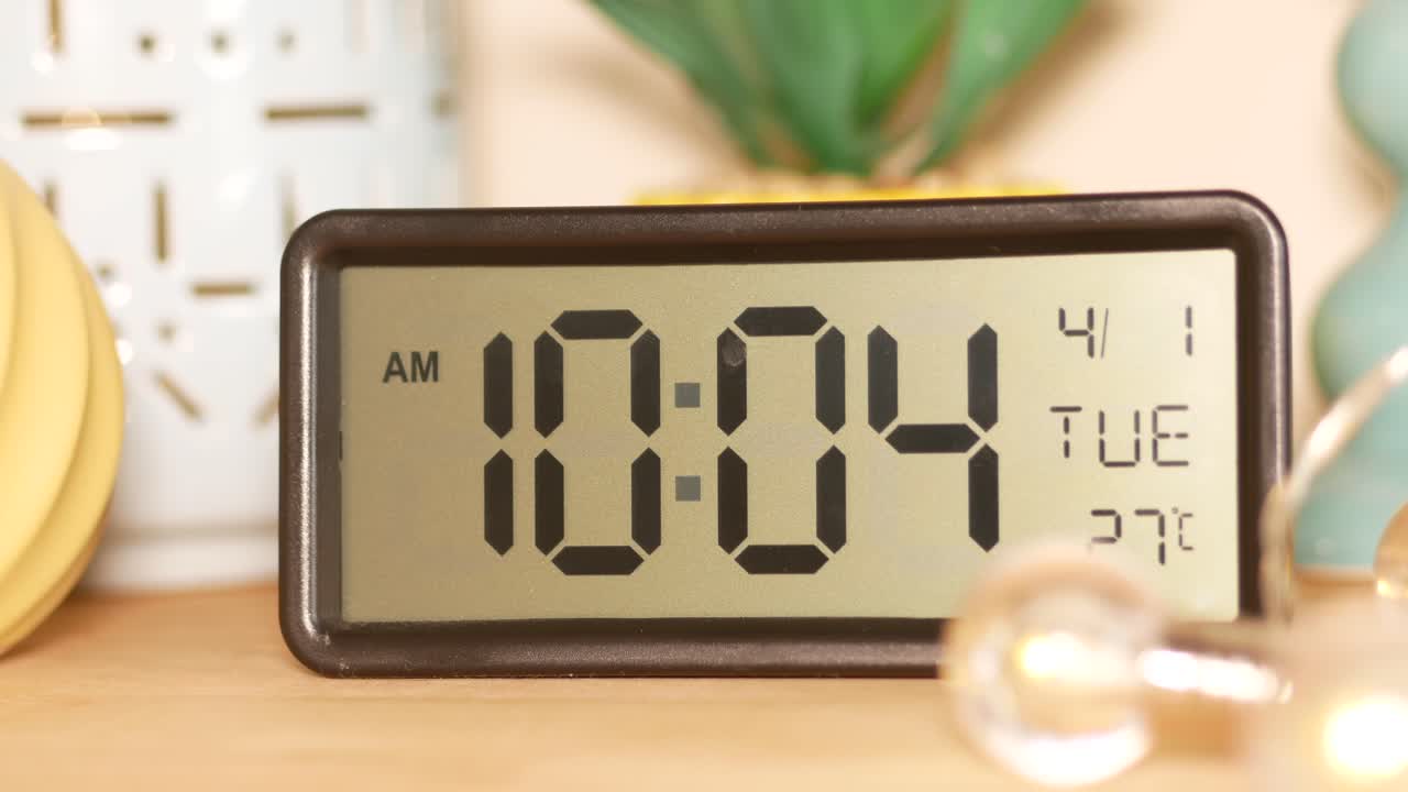 Digital Clock Showing 10:04 AM on a Wooden Table