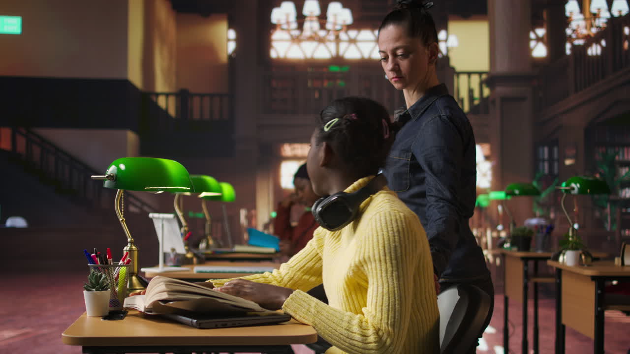 Student Studying in Library with Teacher