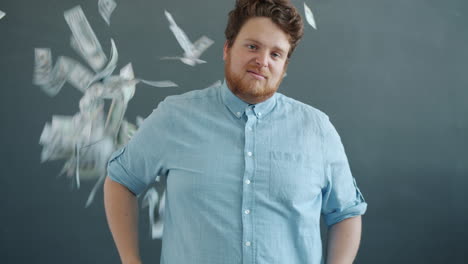 man looking at camera with money falling around