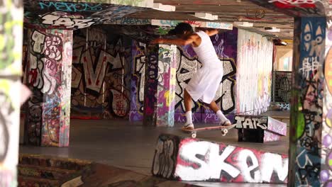 skateboarder performing tricks in urban graffiti setting