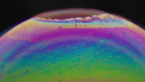 vibrant close-up of colorful soap bubble with iridescent patterns on a black background