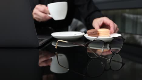 woman eating macaroons at her desk