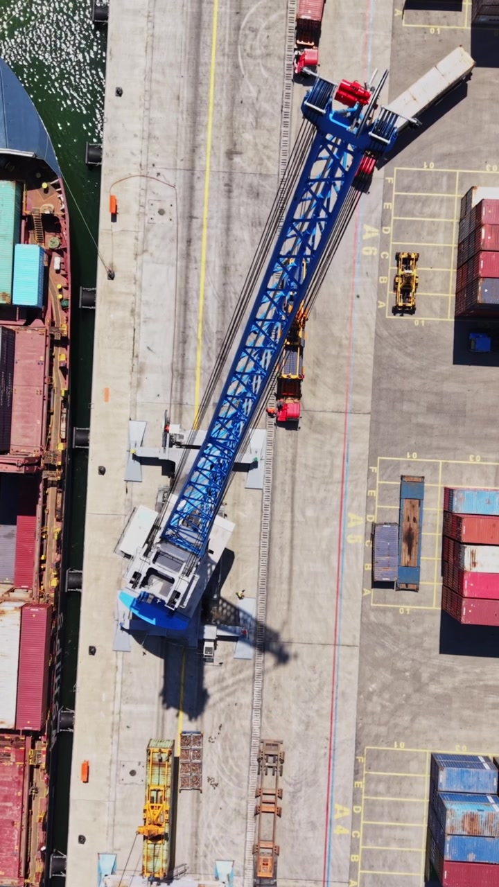 Cargo ship at dock with crane loading containers in busy port area