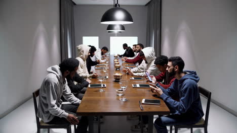 men in hoodies at a conference dinner table