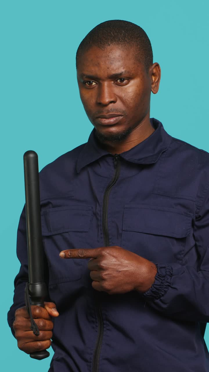 African American Man Holding Police Baton and Pointing