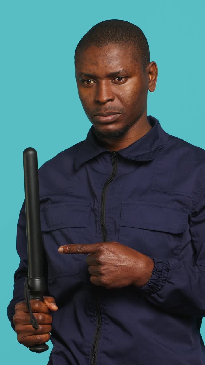 African American Man Holding Police Baton and Pointing