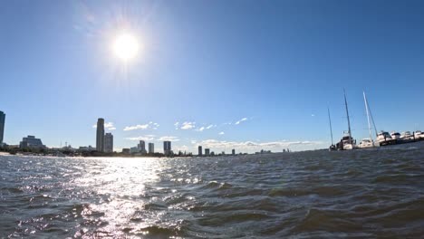 sunlit waterfront with boats and city skyline