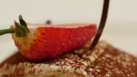 close-up of a slice of strawberry on a tiramisu dessert