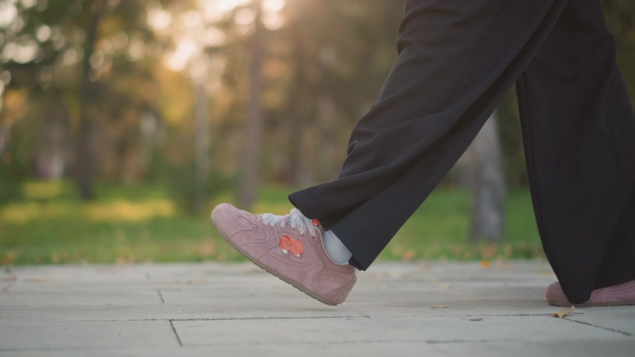 Person Walking in Black Trousers and Pink Sneakers Outdoors