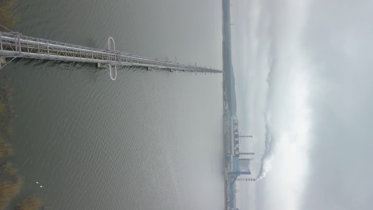 종말 이후 시나리오의 수직 드론이 연기와 오염으로 발전소에 접근하고 있습니다.