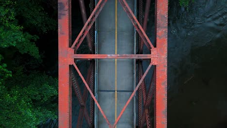 ascending aerial shot of steel bridge over flowing cedar river in washington state