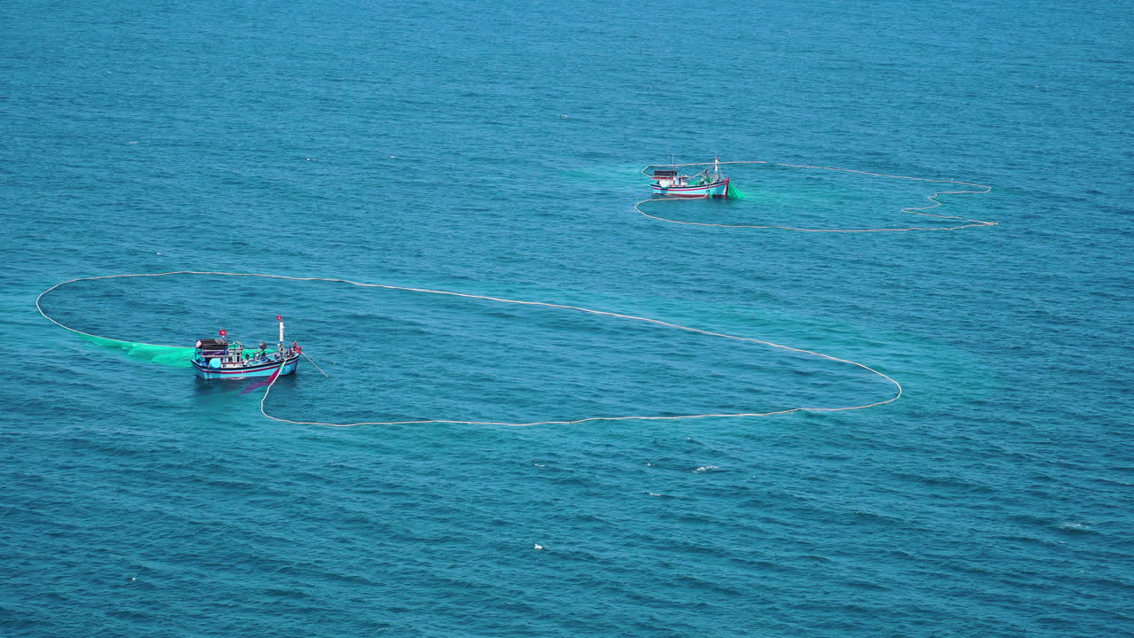 toma estática aérea de barcos en el mar azul haciendo pesca con red