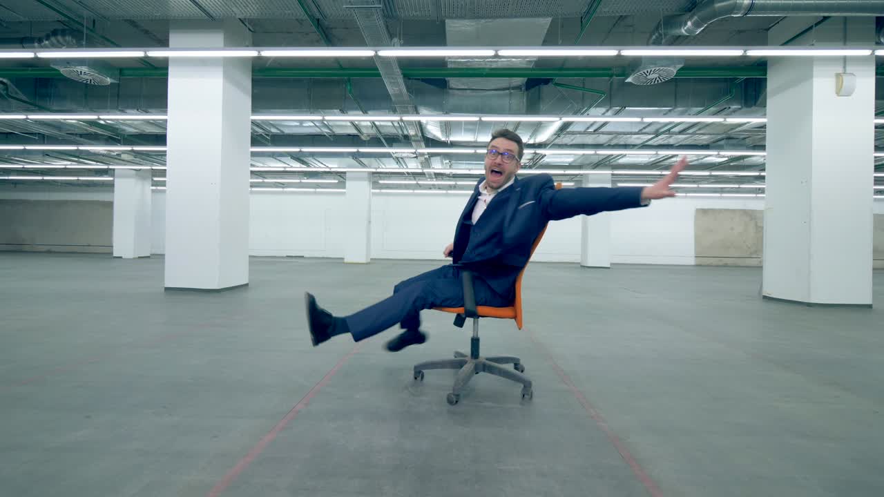 un hombre de negocios en traje está haciendo tonterías en una silla de ruedas.