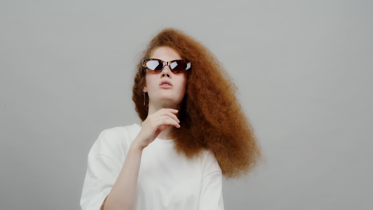 Stylish Girl with Red Curly Hair and Sunglasses