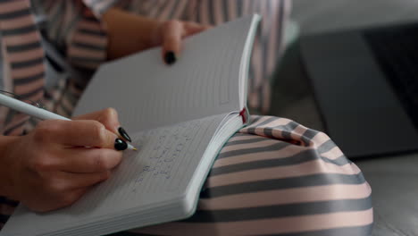 student writing online lecture at home closeup. smart girl studying remotely