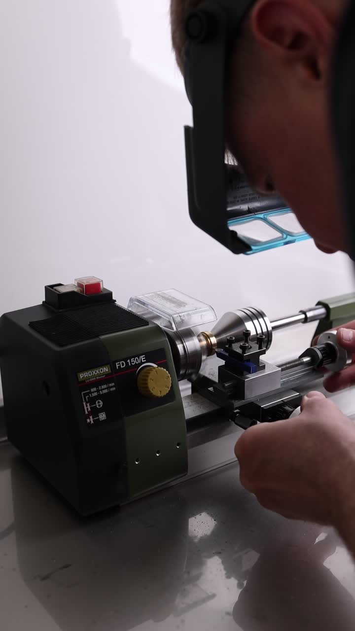 Person Operating a Small Lathe Machine in a Workshop