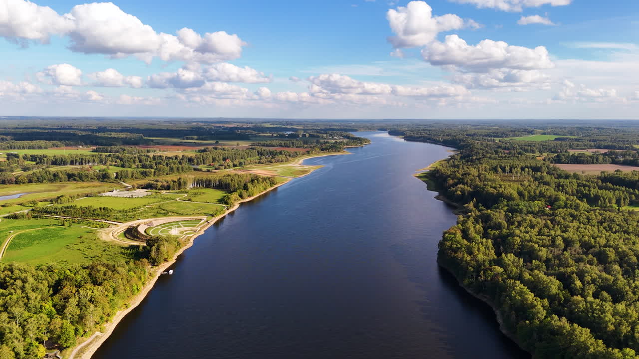 vuelo aéreo paisaje natural letón, río daugava a través de campos rurales boscosos, fondo de horizonte soleado
