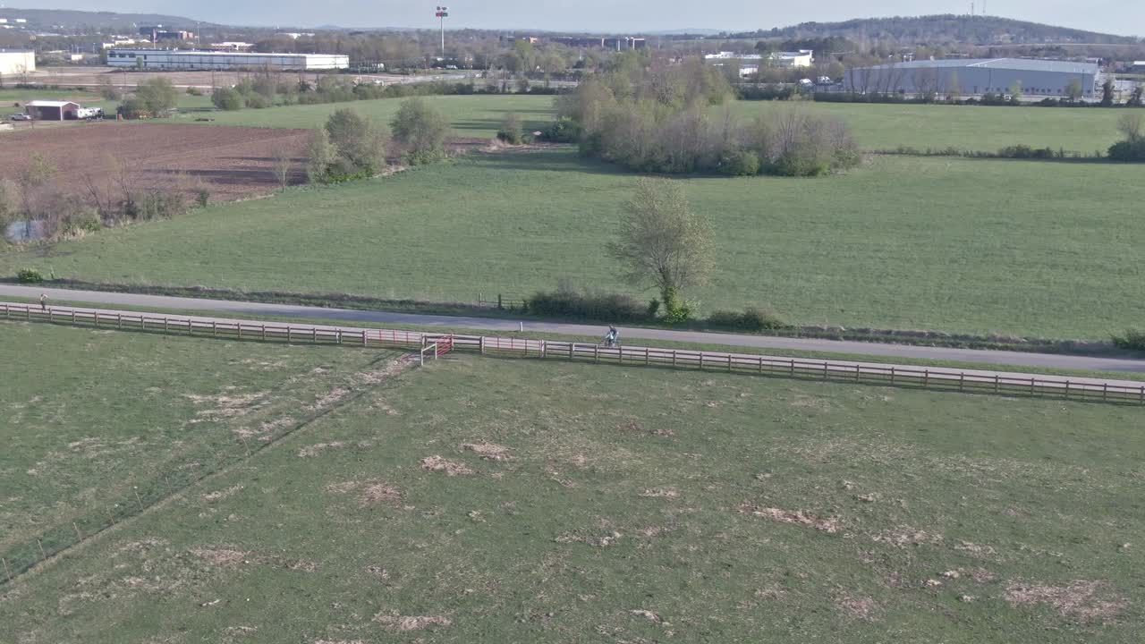 low altitude aerial b-roll of bicyclist riding on a country road