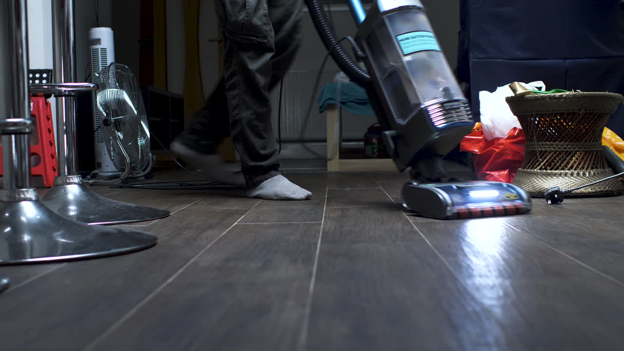진공 청소기로 사무실 바닥을 청소하는 사람
