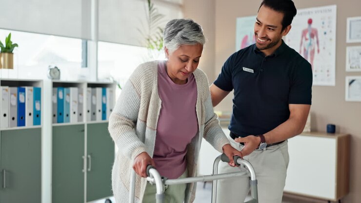 physiotherapeut, der älteren patienten beim gehen hilft