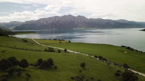 Ein-Wunderschöner-Tag-Mit-Einem-Toyota-Estima-Durch-Ackerland-Mit-See-Und-Bergen-Im-Hintergrund