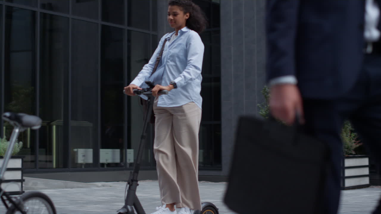 Attractive girl riding electric scooter at downtown district. Urban lifestyle.