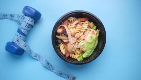 healthy meal prep with dumbbell and measuring tape