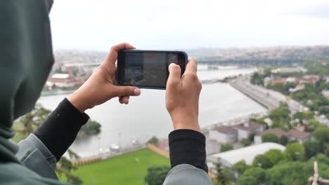 woman taking photo of cityscape from a high point.