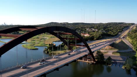 aerial drone forward moving shot over pennyback bridge in austin, texas, usa with a top down view of lake austin on a bright sunny day