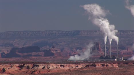 mediumshot of a factory in the arizona desert emitting pollution