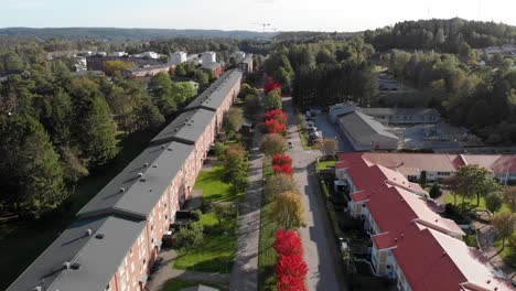 aerial view of a terraced row of sustainable houses bordered by red and green trees