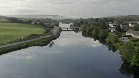 an aerial view of the river shin at lairg on a calm and misty summer's moring