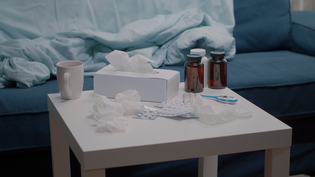 Close up of table with medicaments, thermometer and tissues