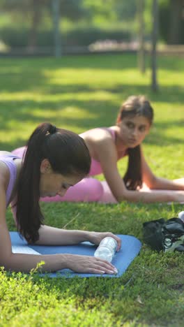 women practicing yoga outdoors in a park