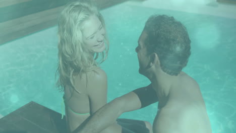 relaxing by swimming pool, couple smiling and enjoying animation together
